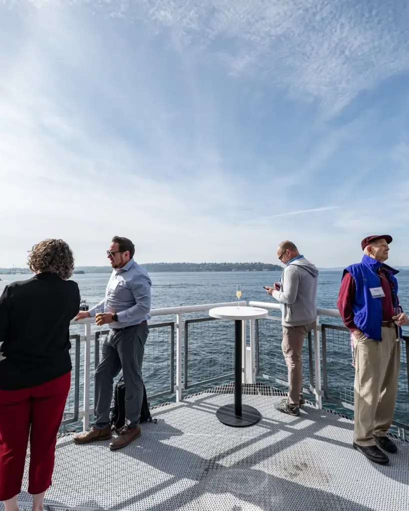 Company event guests on the balcony of The Point at Pier 70, with Elliott Bay stretching to the horizon