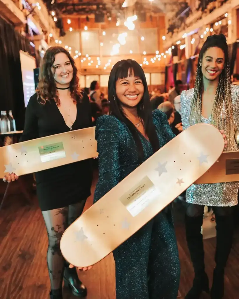 Guests celebrating with award skateboards beneath string lights at a company event at SoDo Park, Seattle