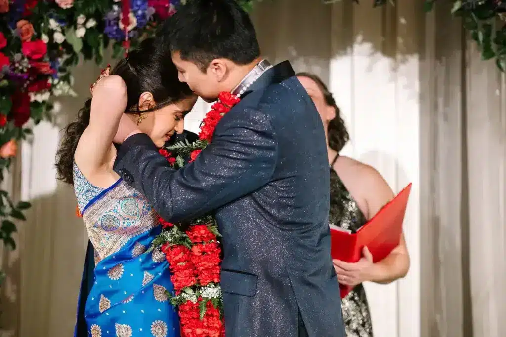 A bride in a blue silk sari and her groom during the garland exchange at Hideaway Cellars, Seattle