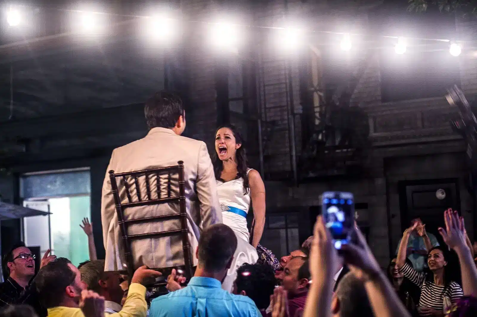 Couple lifted on chairs during a wedding reception with DJ entertainment by Serenada