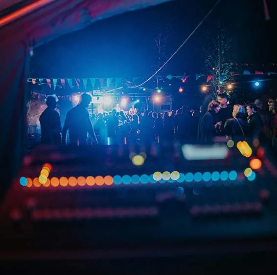 A lighting and sound board running the program at an evening event