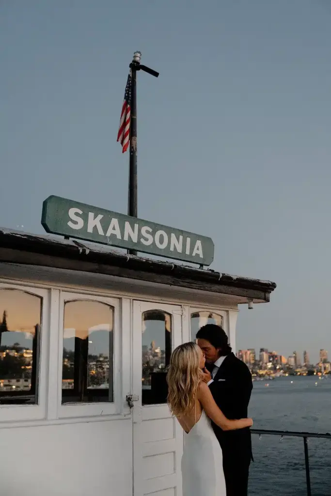 Newlyweds beneath the Skansonia sign at dusk on the MV Skansonia, a historic ferry wedding venue on Lake Union
