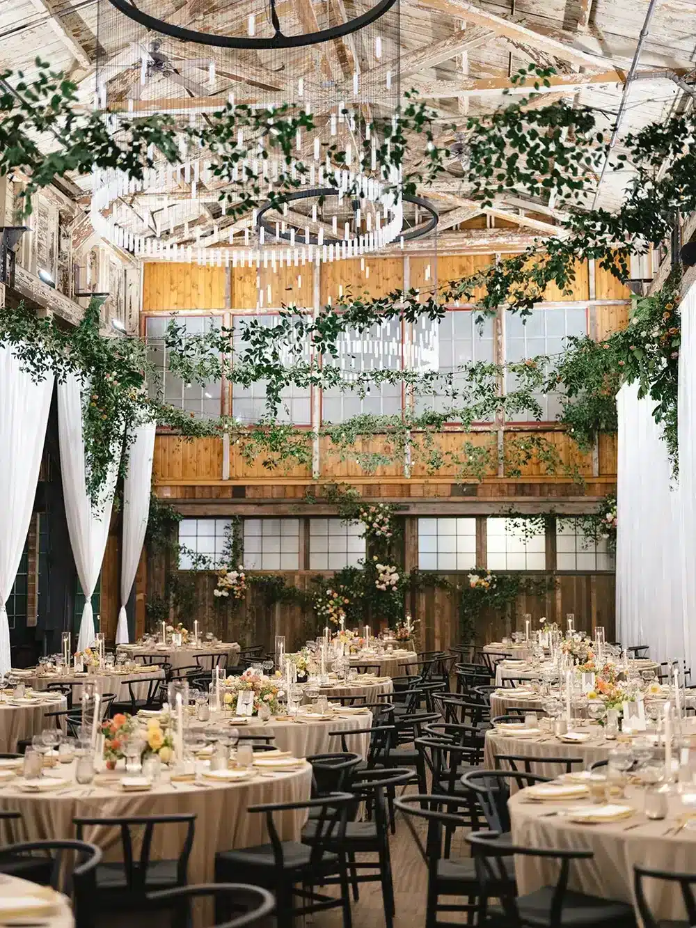 SoDo Park hall dressed in greenery under large chandeliers, an industrial wedding venue in Seattle