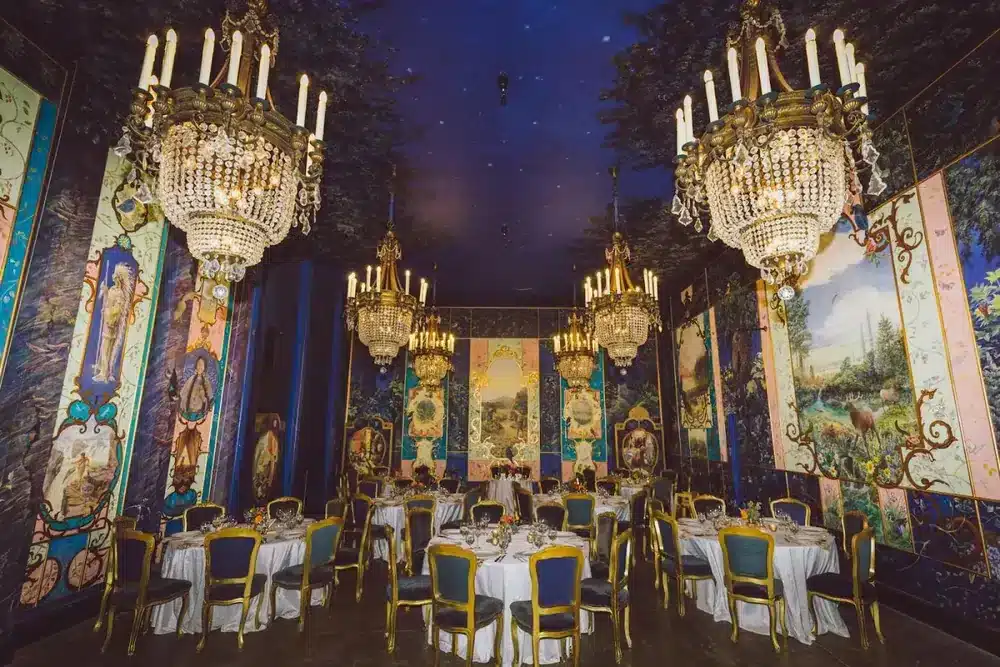 The muraled ballroom at The Ruins set for dinner beneath crystal chandeliers, Seattle
