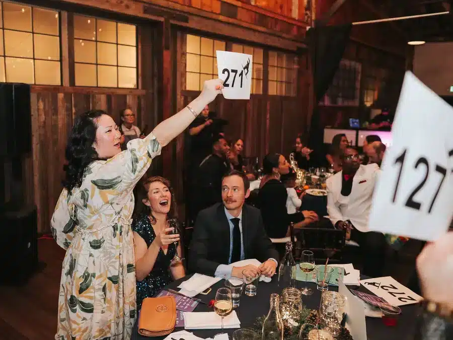 Guests raising bid paddles at a gala at SoDo Park