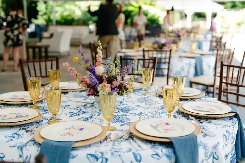 A table set with blue-and-white linens, amber glassware and garden flowers under the tent at Fox Hollow Farm in Issaquah