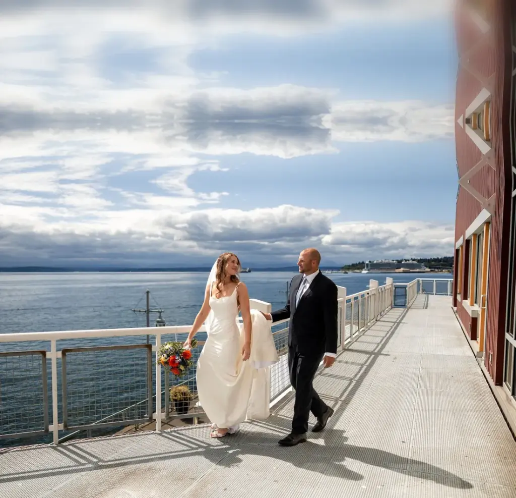 A couple walking the waterfront deck at The Point at Pier 70 above Elliott Bay